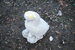 A cast concrete garden statue of a mother duck sur