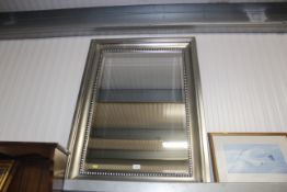 A modern framed and bevel edged wall mirror