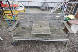 A two seater garden bench with middle fitted table