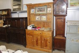 A pine dresser raised on cupboard base fitted thre