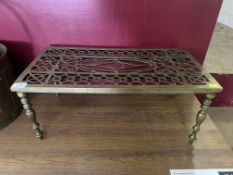 Brass trivet of square form raised on shaped legs.