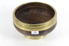A large antique brass rimmed and based wooden bowl of super colour and patina