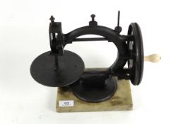 A small Victorian sewing machine on marble base