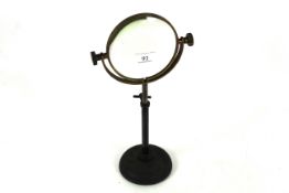 A Victorian brass and cast iron adjustable height magnifying glass on stand