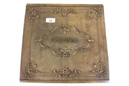 An ornate brass plaque named to 