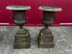 A large pair of cast iron urns set to cast iron plinths, approx. 39