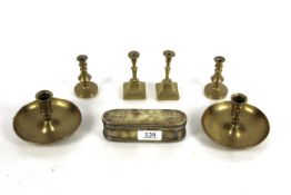 A collection of antique brass including an oblong snuff box, two pairs of taper sticks and a pair of
