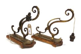 A pair of ornate brass wall sconces on oak mounts