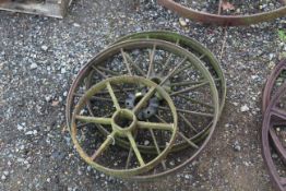 A pair of 12 spoke cast iron wheels and a further small cast iron wheel