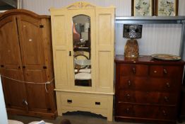 An yellow painted single mirrored door wardrobe, fitted single drawer