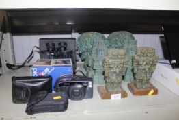 A quantity of Aztec style book ends and figures, together with two pairs of binoculars, a Pentax