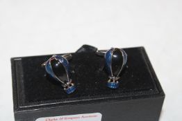 A pair of enamel decorated cuff-links in the form