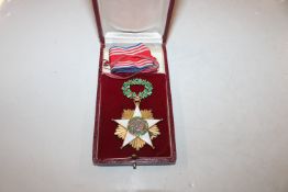 A gilt and enamel decorated medal, 52gms in case w