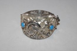 A large vintage silver bangle of Eastern design wi