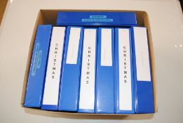 A box containing eight folders of Christmas stamps