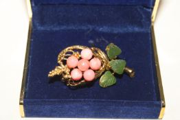 A coral and jade brooch on gold tone metal