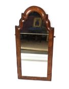 A 19th Century walnut cushion framed mirror, plate in two sections, surmounted by an arched