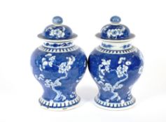 A pair of Chinese blue and white baluster vases and covers, decorated prunus, 4 character mark to