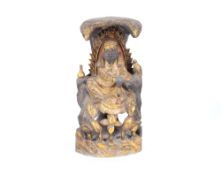 A 19th Century carved and gilt wood Oriental figure, of a seated deity with attendant bird holding a