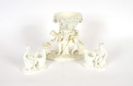 A pair of blanc de chine figural posy vases; and a blanc de chine table centrepiece decorated with