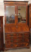 An 18th Century walnut bureau bookcase, the upper section fitted pigeonholes and shelves enclosed by
