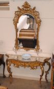 A French style gilded console table, of serpentine form, mirrored top above pierced foliate frieze