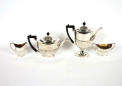 A late Victorian silver four piece tea and coffee set, having half fluted body decoration, the tea