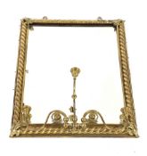 A brass framed wall mirror, fitted with triple candle sconces, rope twist border and foliate