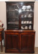 A Victorian mahogany bookcase, the upper section fitted adjustable shelves above cupboards below