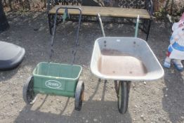 A Scotts seed spreader and a wheelbarrow