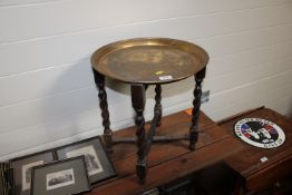 A brass topped circular folding table