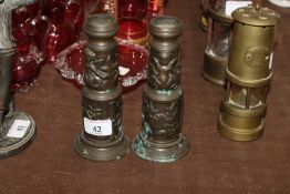 A pair of brass candlesticks decorated with cherub