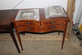 A reproduction mahogany serpentine fronted table fitted two short over single long drawer, having
