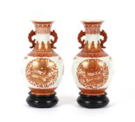 A pair of Chinese baluster vases, decorated dragons and foliage with scrolled handles, 24cm high
