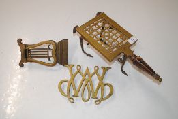 An antique brass and iron trivet dated 1901 and initialled R.O.B. C. J. S; a brass Williamsburg