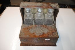 A late Victorian oak and plate mounted three bottle tantalus/games box (locked, no key)