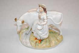 A Staffordshire figure group in the form of cow an