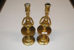A pair of antique brass tavern bell candlesticks