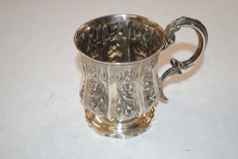 A silver mug with floral decoration, initialled an