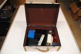 A case containing various costume jewellery and em