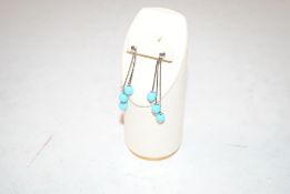 A pair of turquoise coloured bead decorated drop e