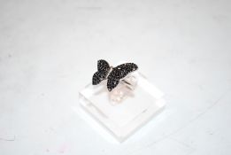 A sterling silver and black diamond butterfly ring