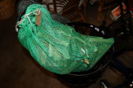 A netted bag containing a quantity of kindling