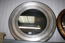 A modern framed circular wall mirror
