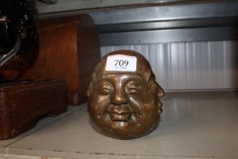 A reproduction ornament of a four faced Buddha hea