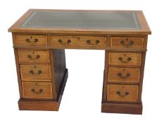 A mahogany and crossbanded pedestal desk, the top inset with a green leatherette tooled panel, above