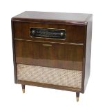 A Ferguson radiogram, in walnut case, with a radio tuner, above a fall front door, enclosing