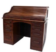 An early 20thC walnut roll top desk, the tambour front enclosing a fitted interior, above an