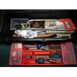 A black plastic toolbox, containing hand tools including screwdrivers, screwdriver bits, screws,