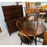 An Ercol dark elm dining suite, comprising a drop leaf table, five chairs, including one carver,